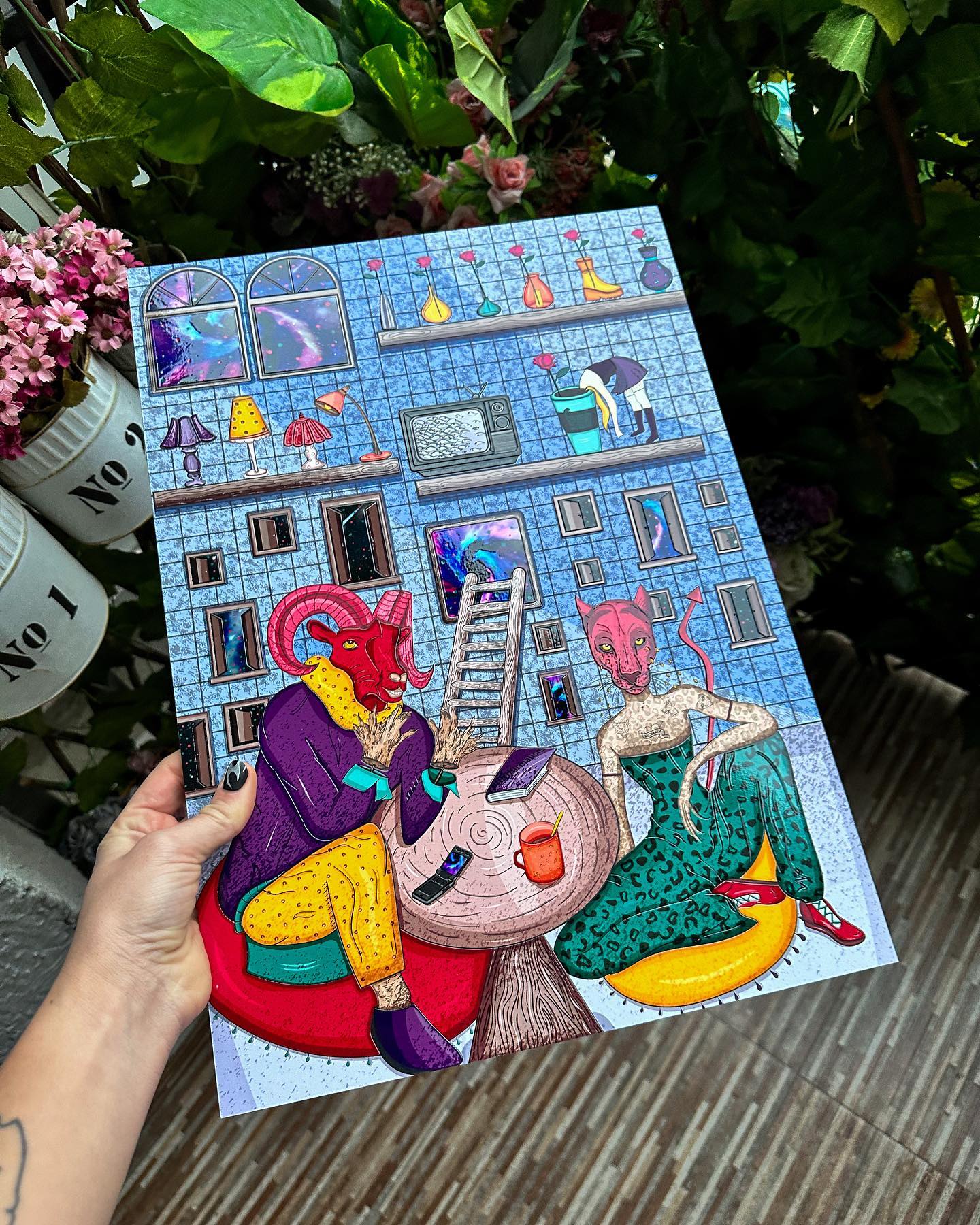 Colorful illustration of building with gray color, blue windows, and pink roof with two characters in front of it, one red cat-like creature wearing yellow suit and one pink goat-like creature wearing green dress sitting on large orange cup with face on it.