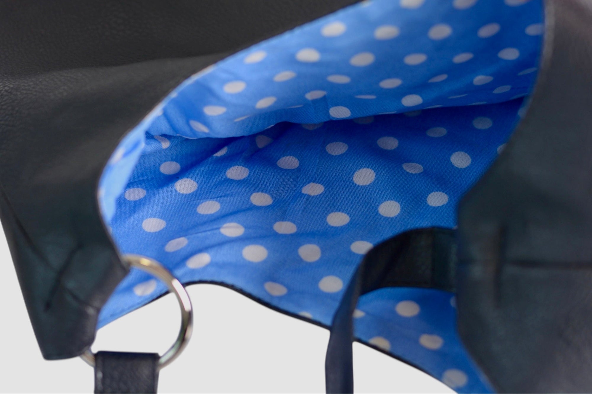 Interior view of the Omashu Sylvie bag showcasing its spacious design and vibrant blue lining with white polka dots.