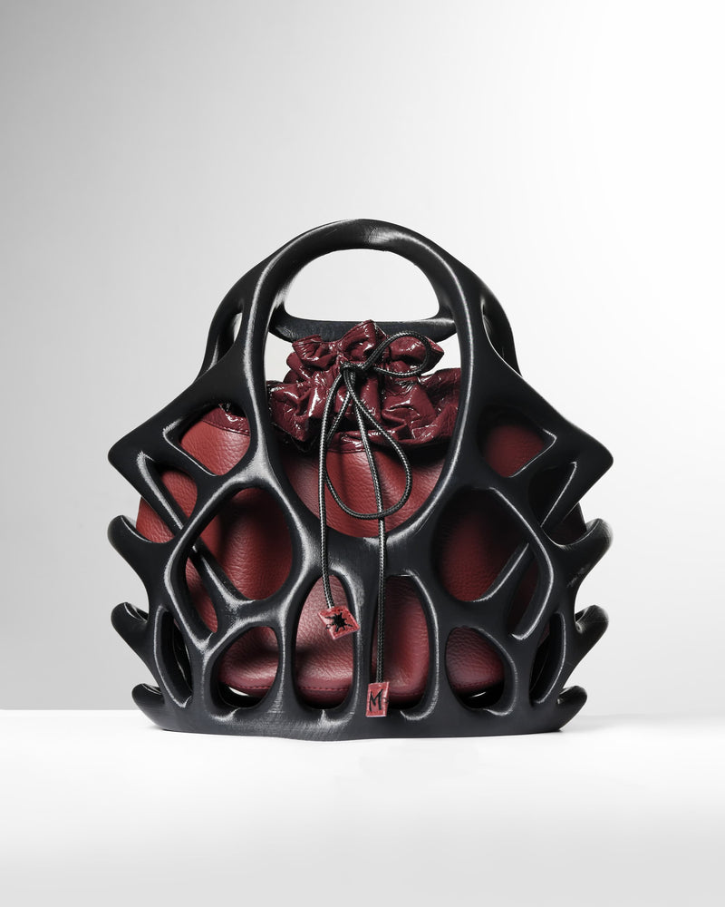 Black and red handbag with floral design on a white background