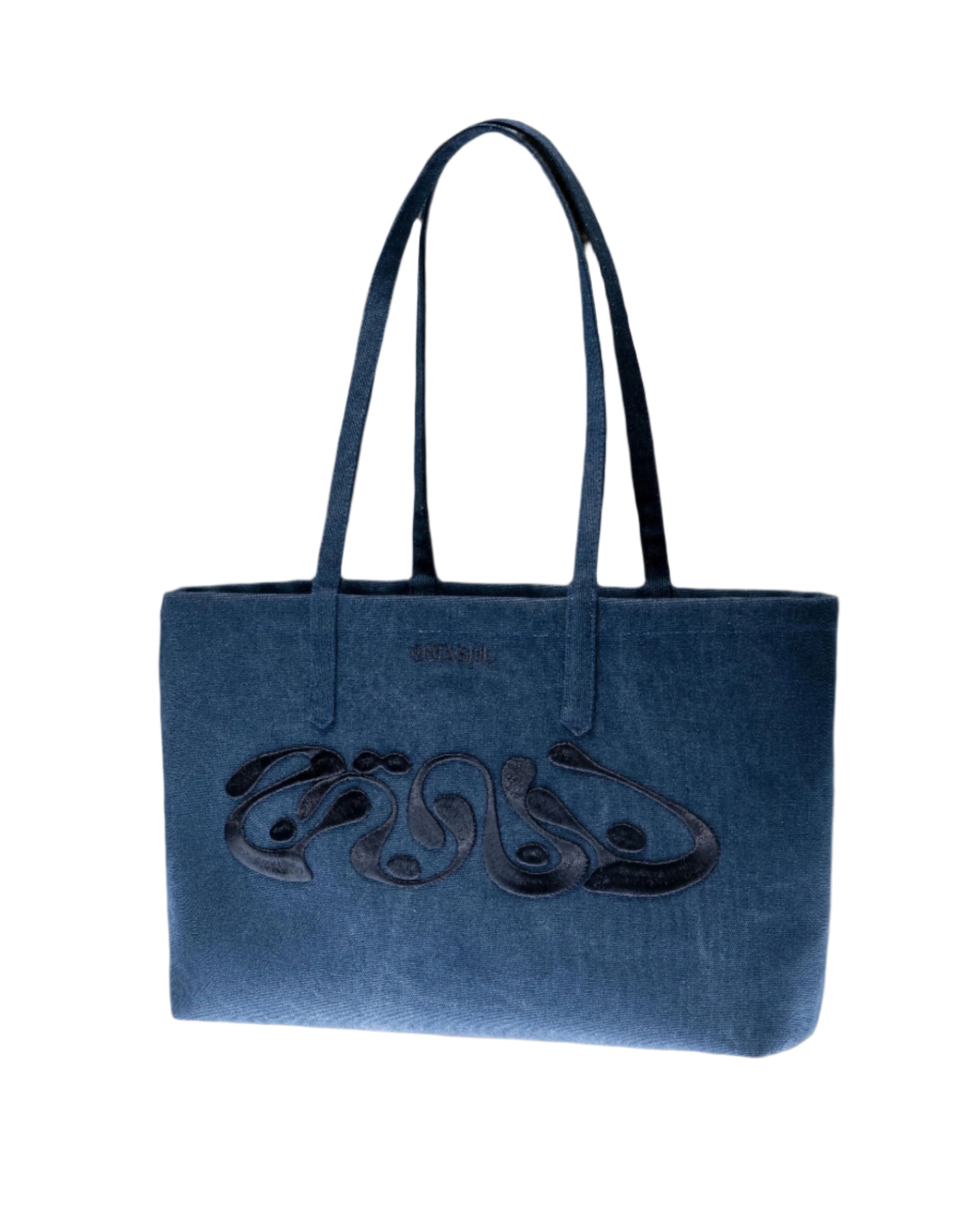 A structured blue velvet tote bag with two top handles, featuring abstract black embroidery across the front. The bag is placed against a light background for a studio shot.