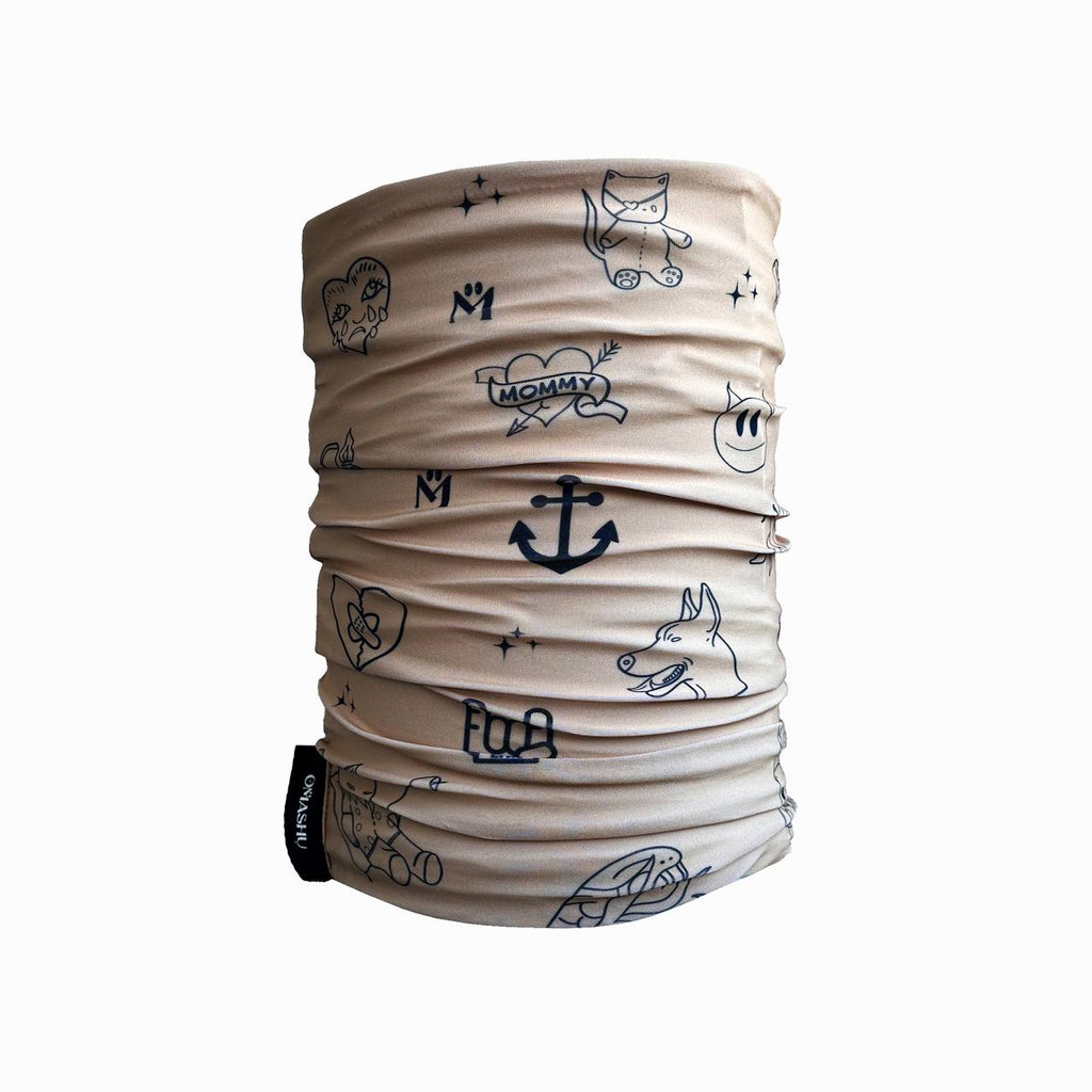 A beige neck gaiter featuring simple black line drawings of various quirky illustrations, such as a heart, anchor, dog, and cute characters. The drawings are scattered randomly, creating a fun and artistic look.