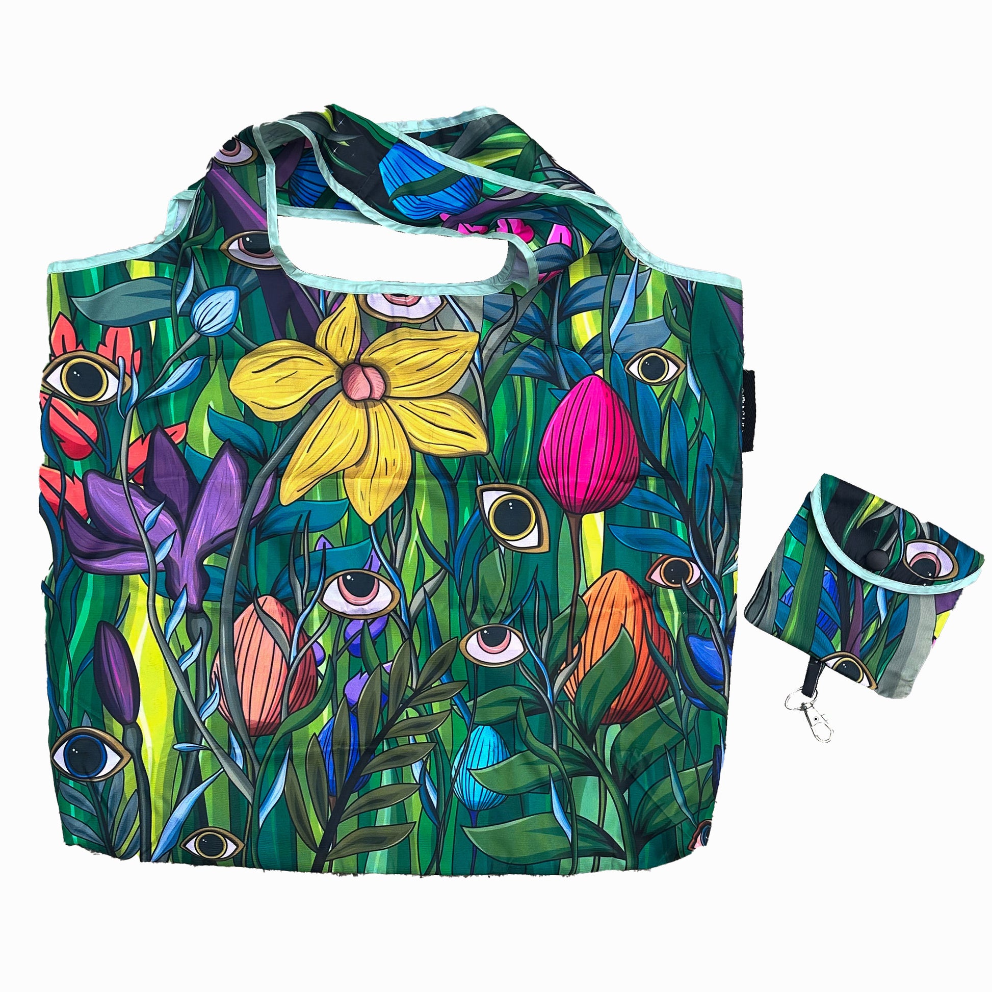 a vibrant reusable shopping bag adorned with a detailed floral pattern. The bag features prominent yellow flowers, various green leaves, and whimsical eyes interspersed throughout. A matching pouch accompanies the bag.