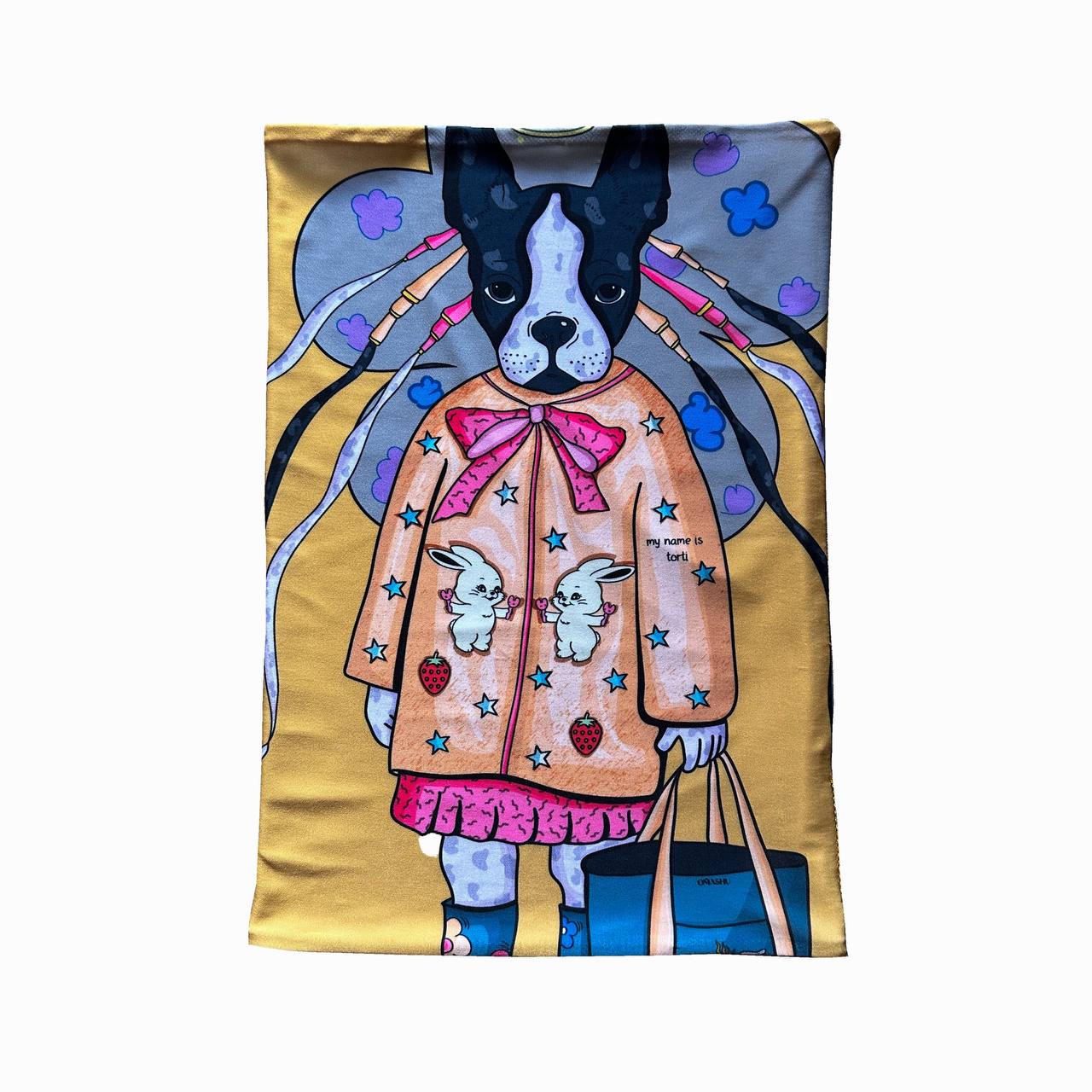 A rectangular fabric with a French Bulldog illustration wearing a whimsical coat, similar to the previous image but featuring a yellow background. The dog’s coat is decorated with bunnies, stars, and strawberries, giving it a cute and imaginative vibe.