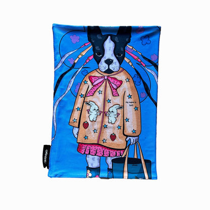 A rectangular fabric with a full illustration of a French Bulldog wearing a pink coat with bunnies, stars, and strawberry accents. The background is a bright blue, adding a fun and colorful touch to the whimsical design.