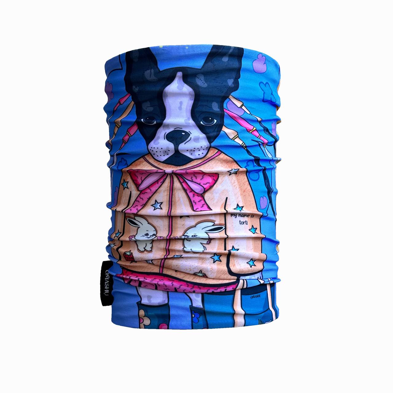 A colorful neck gaiter featuring a French Bulldog wearing a whimsical coat decorated with bows, stars, and bunny illustrations. The background is vibrant blue with pink accents, and the dog's serious expression adds a playful contrast to the fun design.