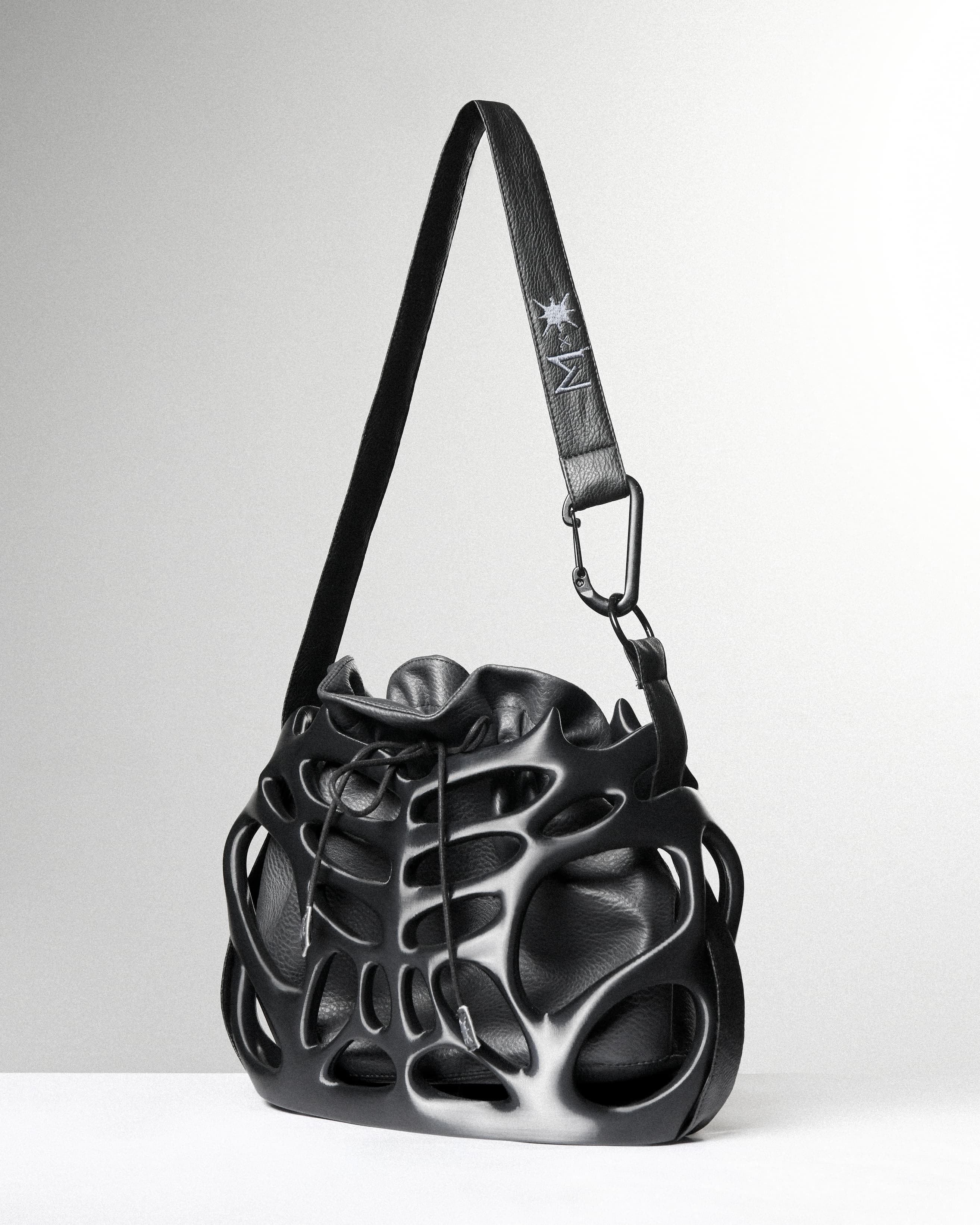Black leather handbag with unique design on a white background