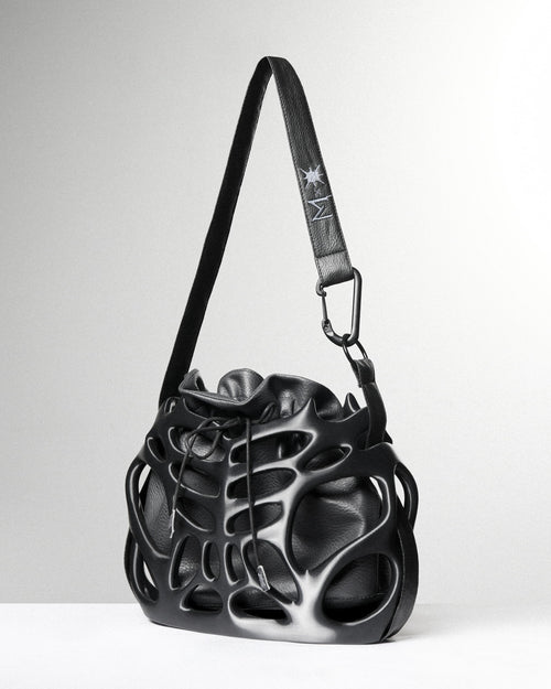 Black leather handbag with unique design on a white background