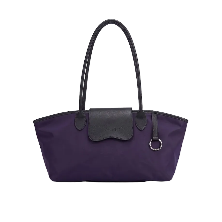 A purple nylon tote bag with black leather handles, trim, and a front flap pocket, shown against a light gray studio background.