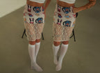 A person wearing a fitted skirt with the same cartoon animal pattern on top and a lace fabric below. The skirt is paired with white knee-high socks, and the image is mirrored to show the outfit from two angles.