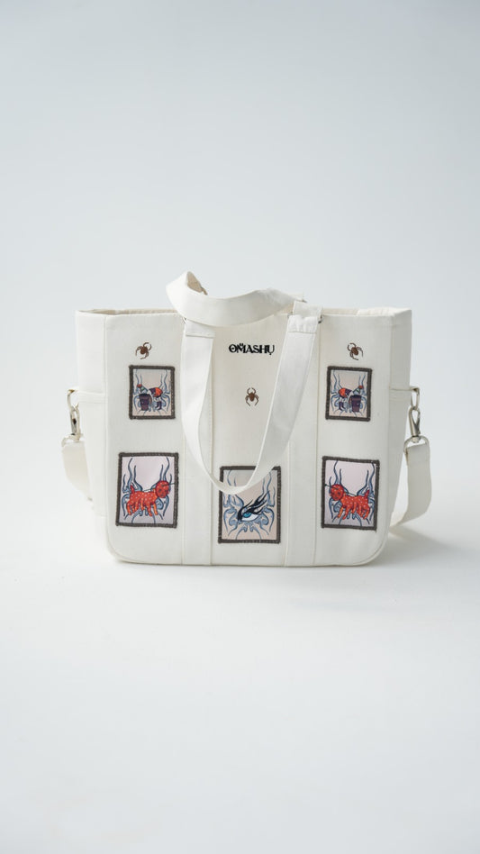 Omashu white tote bag with embroidered patches and laptop divider, featuring bold, street-style graphics.