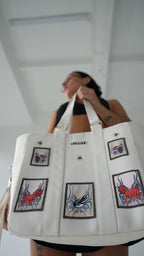 Close-up of Omashu white tote bag with unique embroidered patches, blending street fashion and functionality.