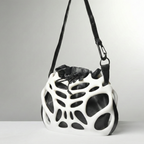 Black and white geometric-patterned bag on a gray background