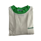 White t-shirt with a green collar and a small green text on the bottom right corner that reads ‘OMASHU’. The t-shirt is neatly folded and has a tag on the inside of the collar.