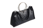 Black bag features a circular and wavy metallic embellishment on the front. Made from faux leather material. with rings up