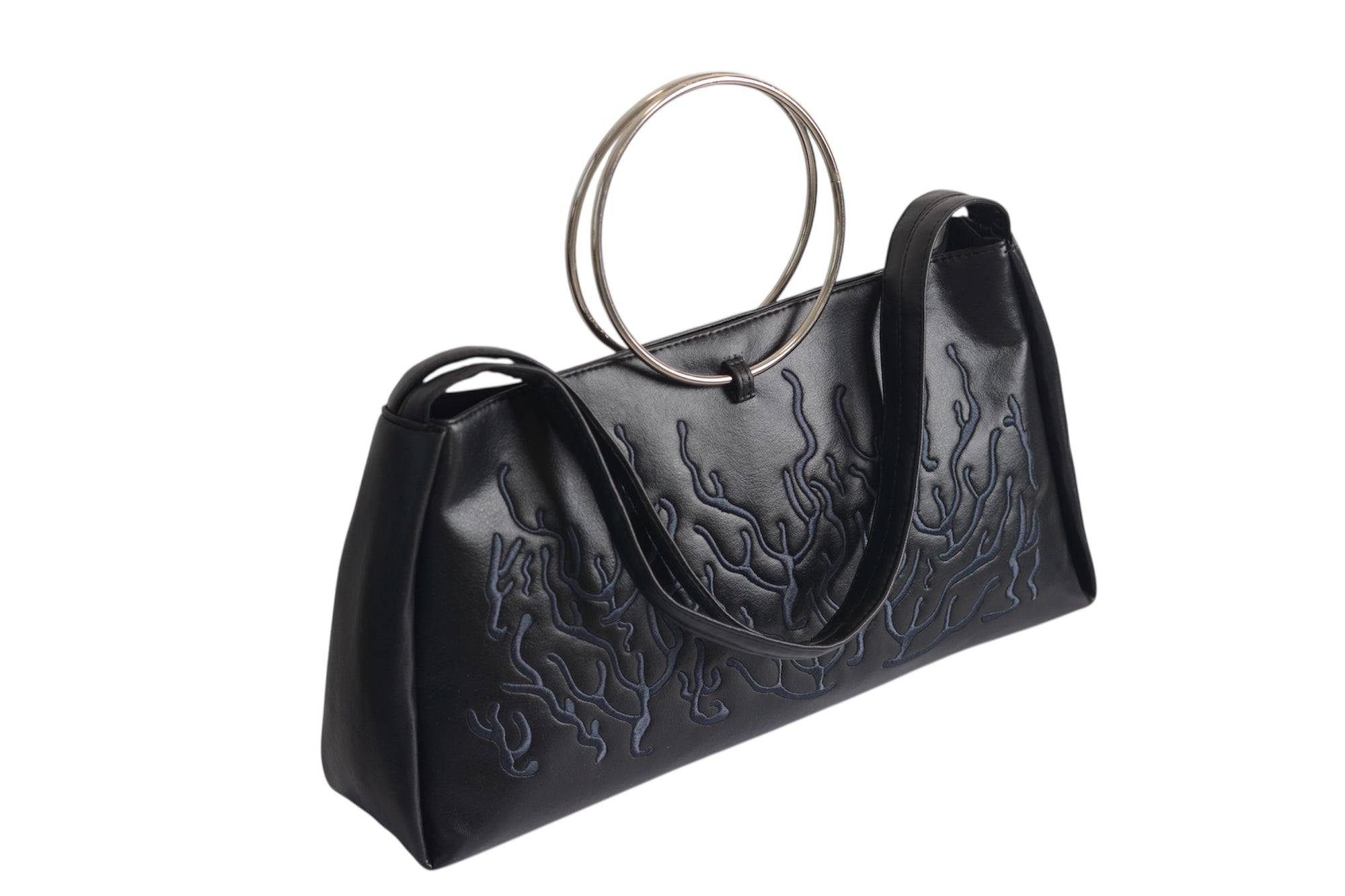 Black bag features a circular and wavy metallic embellishment on the front. Made from faux leather material. with rings up