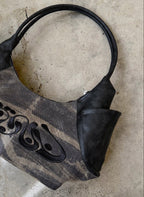 Black handbag on a textured stone surface