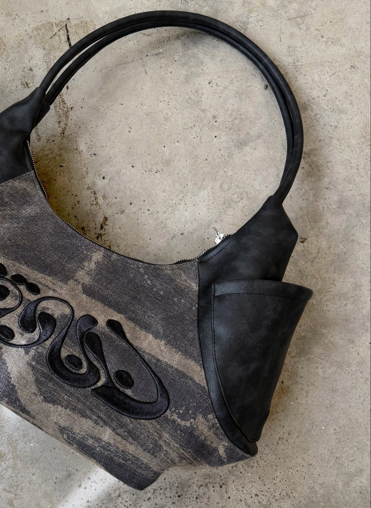 Black handbag on a textured stone surface