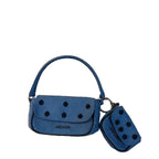 A blue suede mini handbag with a matching coin purse, both featuring black polka dots and the brand name  printed in black on the front, set against a solid black background.