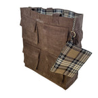 A brown corduroy tote bag with a plaid wallet attached to it. The bag has two handles and a small label on the top left corner that reads ‘OMASHU’. The wallet is attached to the bag with a silver chain and has a plaid pattern in brown, black, and white.