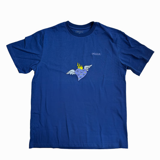 a blue t-shirt with graphic design on the chest area features a heart with wings and flames on its head. The crew neck style with short sleeves. The brand of the t-shirt is “Omashu”, which is written in small white letters on the back of the neck and on chest.